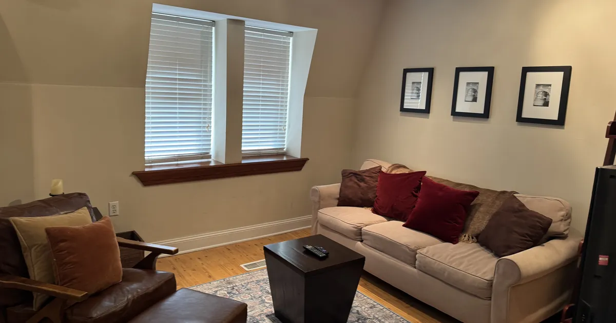 Tidy living room with a sofa, armchair and area rug in a Town and Country area home