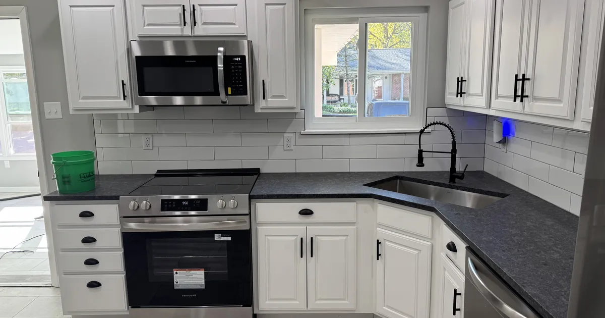 Bright clean kitchen with white cabinets, stainless steel appliances and dark countertops in a St. Louis home